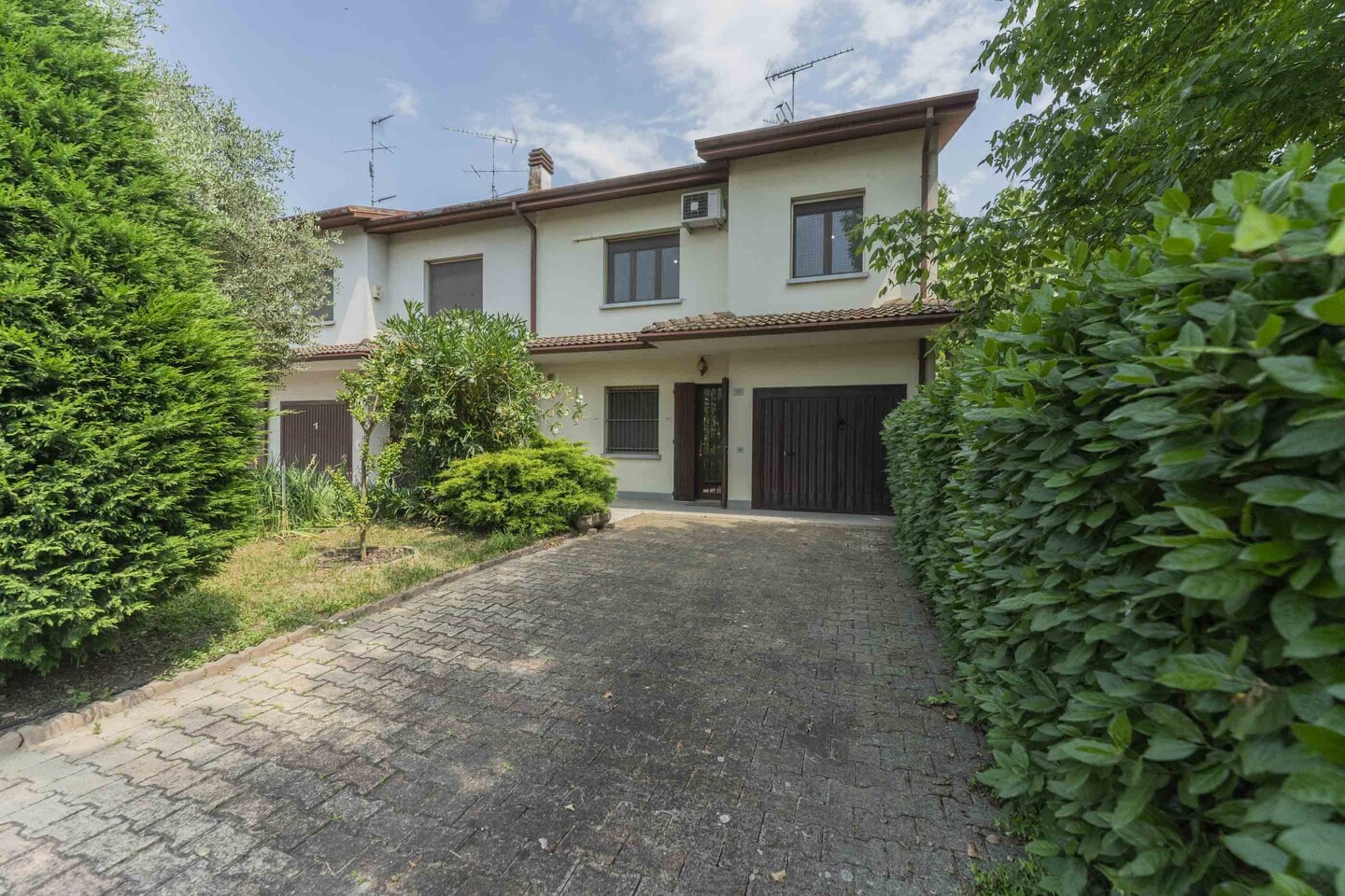 Villetta a schiera di testa con garage, parcheggio scoperto nella corte privata e giardino